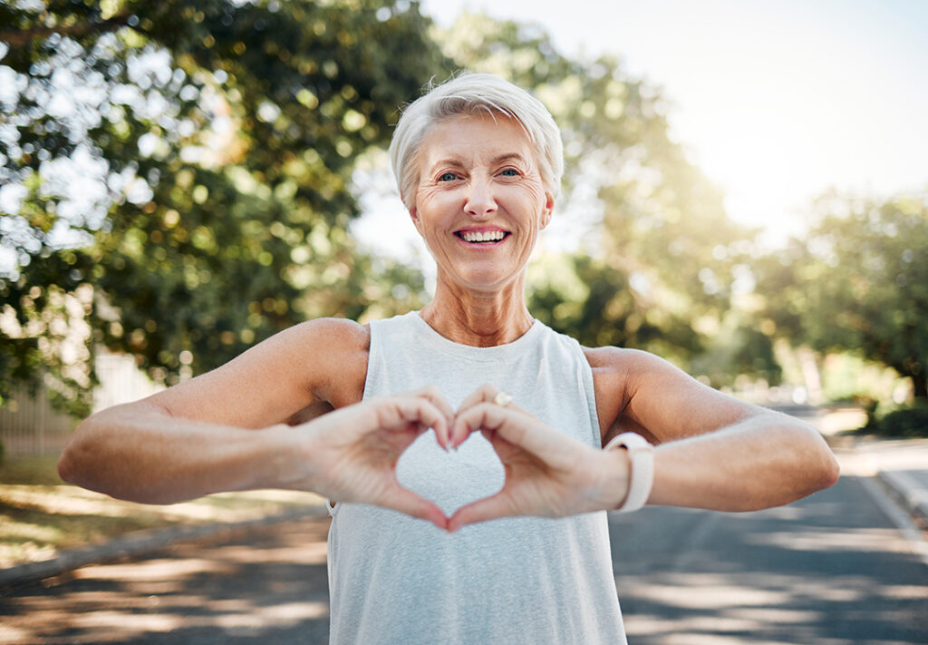 Older woman in great shape holding her hands in front of her chest in the shape of a heart